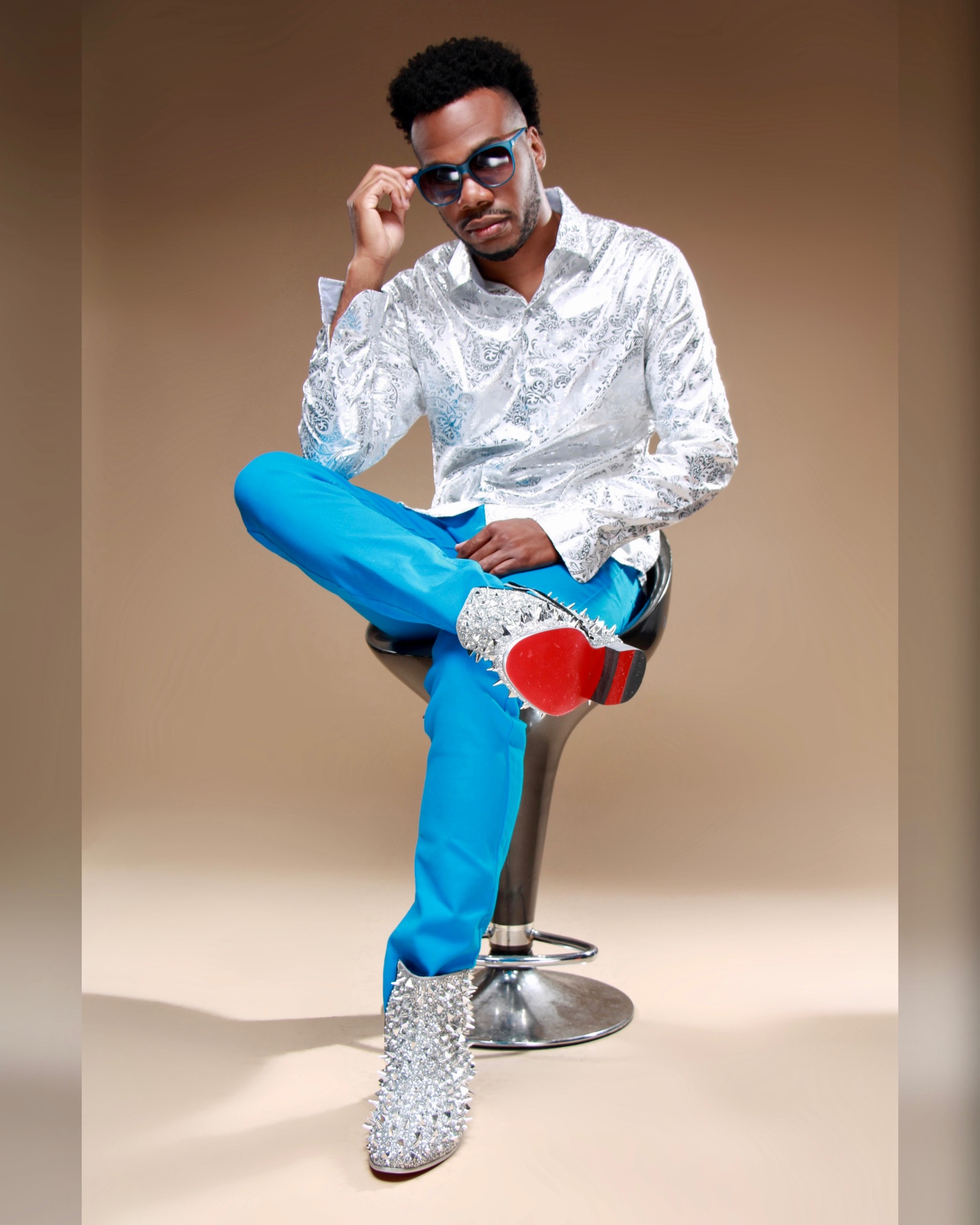 Jerry Stacks in a silver paisley shirt and blue trousers, studio portrait