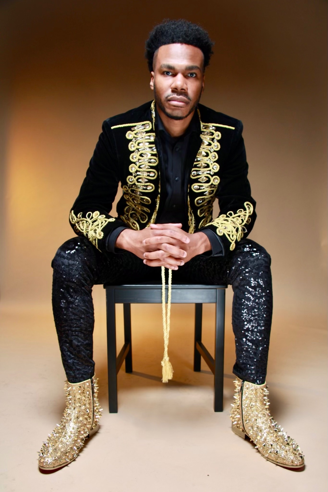 Jerry Stacks in a black velvet jacket with gold embroidery, studio portrait