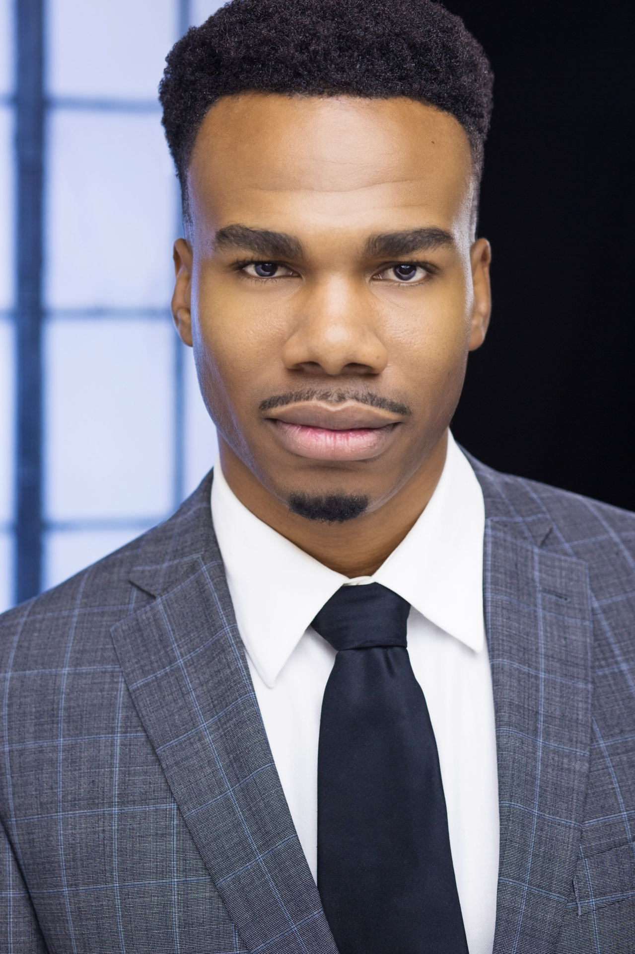 Jerry Stacks headshot in a grey checked suit and black tie